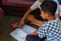 Syaifudin Azim (9) belajar di rumah ditemani ayahnya setelah kasus dugaan perundungan di sekolah dilaporkan ke polisi dan sudah dilakukan klarifikasi, Sabtu (2/5/26).