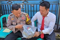 Dua anggota polisi mengamankan barang bukti cobek batu dari dalam rumah duka yang digunakan pelaku untuk menganiaya ibu kandungnya hingga meninggal dunia, Senin (11/5/26).