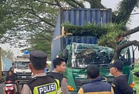 Posisi truk kontainer yang mengalami pecah ban di jalur pantura wilayah Kecamatan Subah usai menyeruduk pohon dan tertimpa dahan berukuran besar menyebabkan ringsek di kabin kemudi, Jum'at (22/5/26). Foto : Istimewa