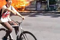 Seorang pelajar melintas di Jalan Merdeka saat kobaran api menghanguskan tiga lapak usaha milik warga di lahan eks Bioskop Merdeka, Jumat (10/7/26). Foto : Istimewa